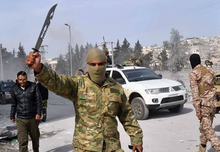 مسلح في عفرين يحمل سيفاً بالقرب من أحد أبرز معالم المدينة الكردية شمال سوريا