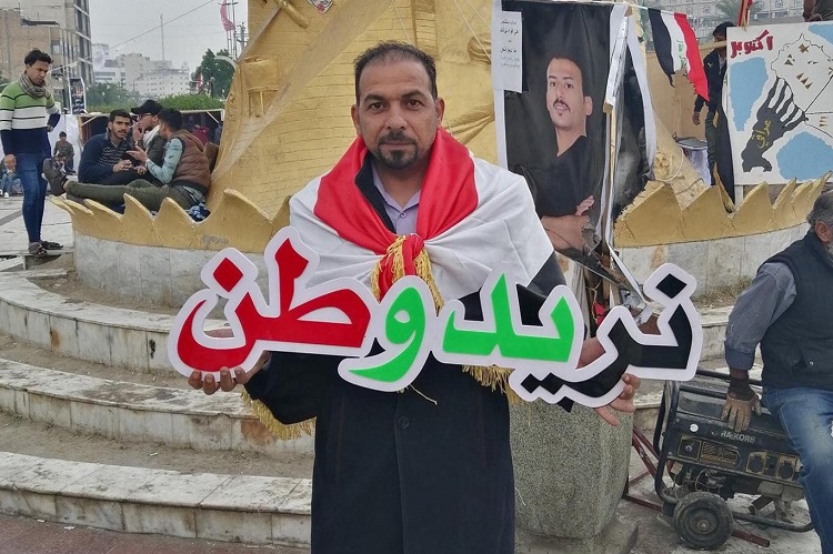 الناشط الكربلائي المغدور إيهاب الوزني يحمل شعار &quot;نريد وطن&quot; في احتجاجات سابقة