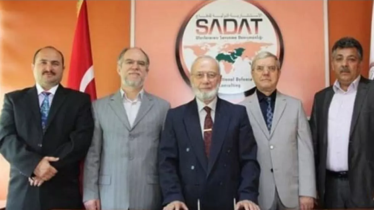 عدنان تانري فردي (وسط) بين مجموعة من المسؤولين في شركة سادات