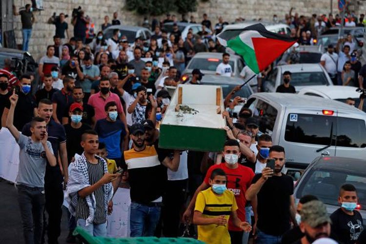 متظاهرون فلسطينيون يسيرون في موكب جنائزي رمزي في حي سلوان في القدس المحتلة - (ا ف ب)