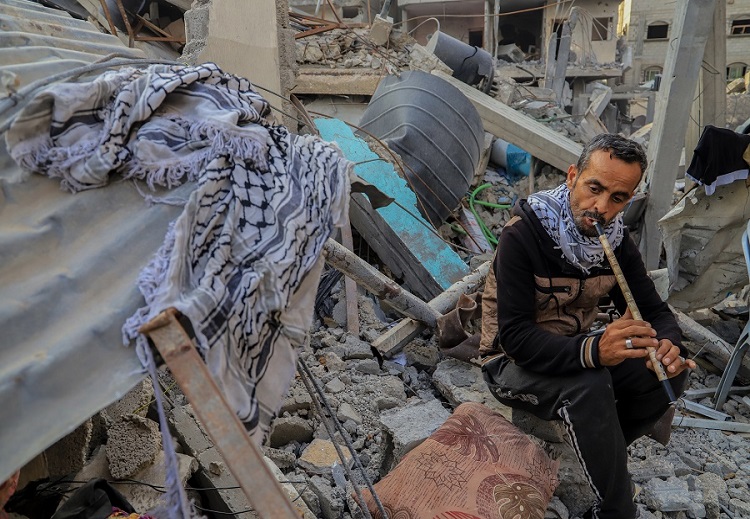 فلسطيني في قطاع غزة يعزف من فوق االركام
