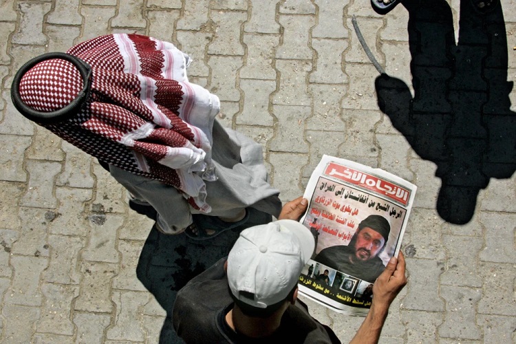 شاب عراقي يلقي نظرة على صورة زعيم القاعدة المقتول أبو مصعب الزرقاوي في صحيفة عراقية ببغداد في 13 يونيو / حزيران 2006