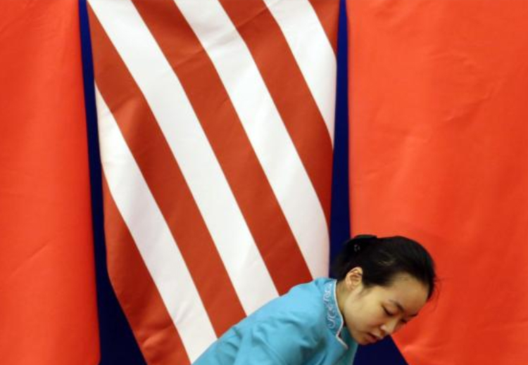امرأة تنظف السجادة خلال حوار أمريكي - صيني بقاعة الشعب الكبرى في بكين، يوليو 2014 (رويترز)